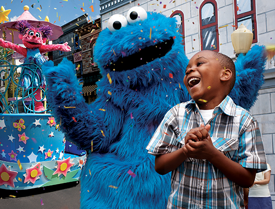 At SeaWorld San Diego, a boy smiles as he interacts with the characters from Sesame Street