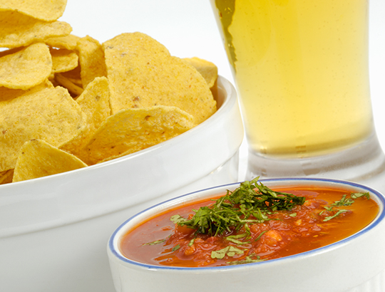 Close up of chips, salsa and a beer glass
