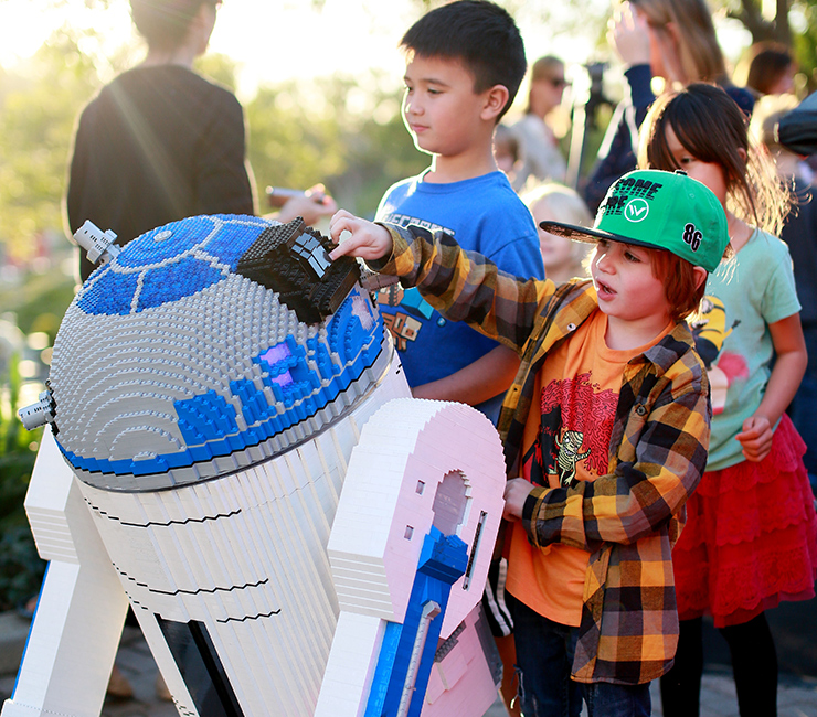 At LEGOLAND California, young boys and girls interact with a life-size Lego created R2-D2 star of Star Wars